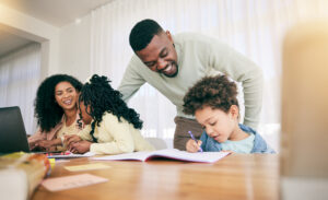 A joyful family at a table, engaging in a learning activity.
