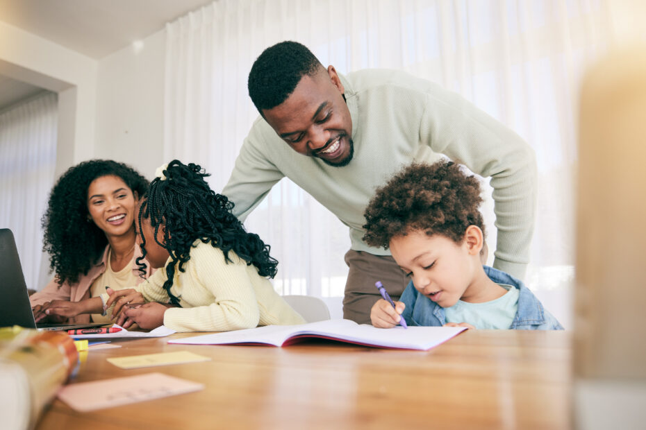 A joyful family at a table, engaging in a learning activity.