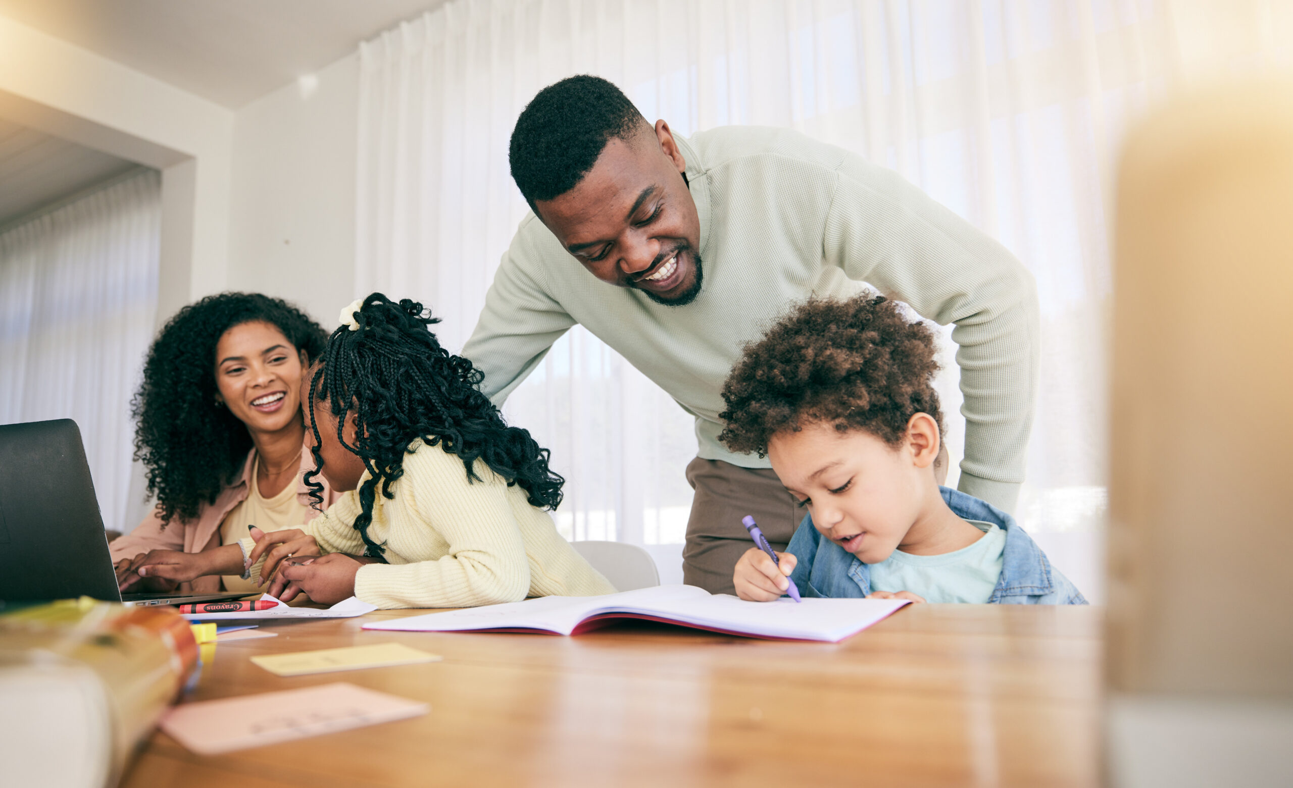 A joyful family at a table, engaging in a learning activity.