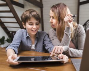 A homeschool mother and a child happily focus on a tablet, suggesting engagement in learning. Text below reads, "Using AI in Homeschooling: A Practical Guide for Parents."
