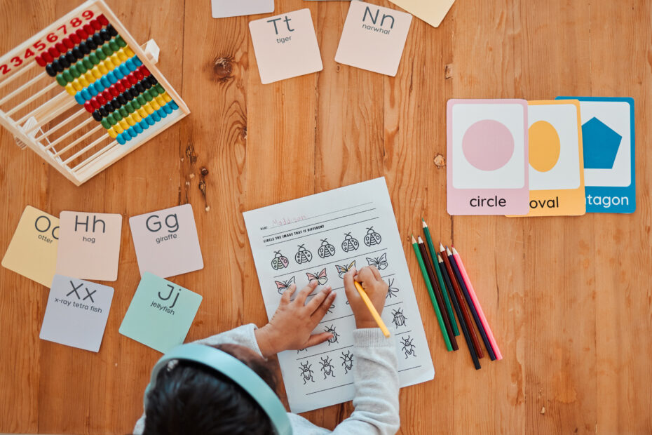 Child working on a math worksheet with colorful pencils, letter and shape cards, and an abacus on a wooden table. Text overlay: "9 Ways to Grow Your Homeschoolers Love of Math."