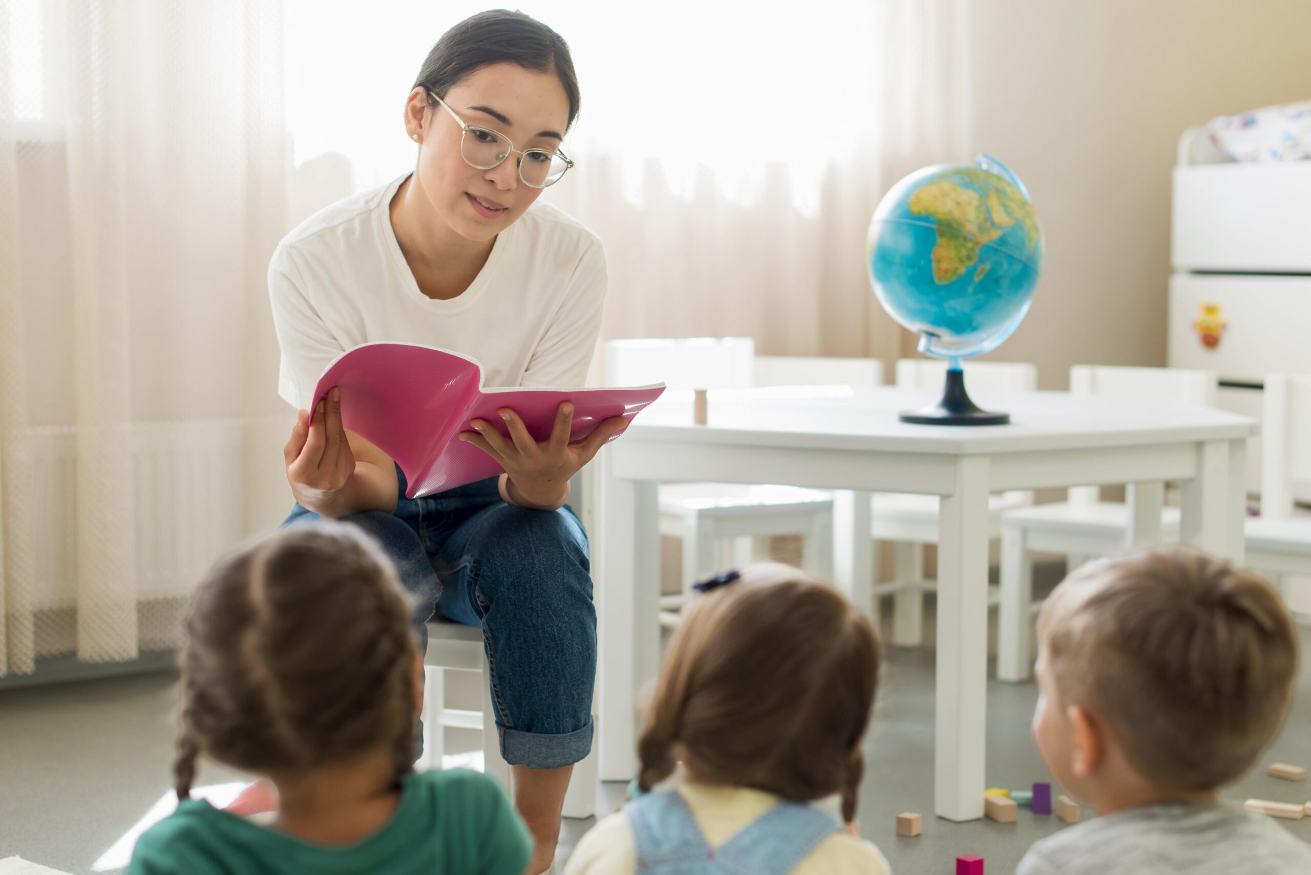 A microschool teacher sits in a classroom reading to students. Text Reads "Federal Education Freedom Tax Credit Could Impact Microschools" on red backround. Logo reads "Homeschool Boss"